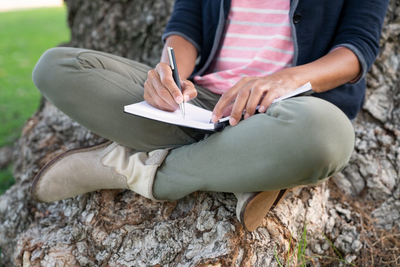 Woman writing in her journal in the park