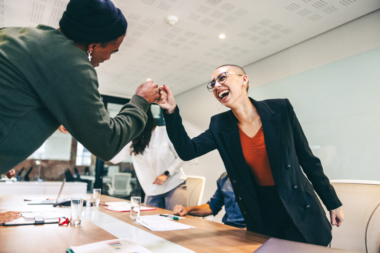 Young businesspeople fist bumping each other before a meeting