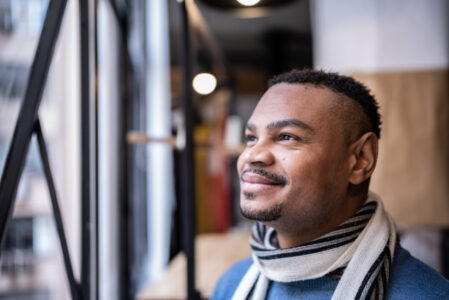 Contemplative mid adult man lookig through the window
